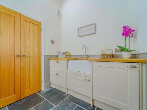 a kitchen with white cabinets and a vase of flowers at 2 Bed in Montgomery oc-83243 in Llandyssil +24 photos