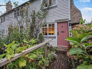 a house with a pink door and some plants at 1 Bed in Northiam oc-bt033 in Northiam