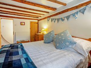 a bedroom with a bed with blue and white sheets at 1 Bed in Northiam oc-bt033 in Northiam