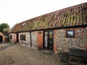 an old brick building with a bench in front of it at 2 Bed in Briston oc-kt009 in Briston