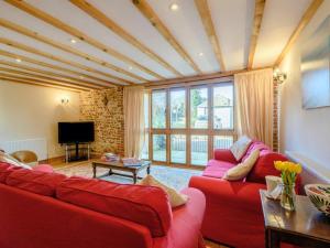 a living room with two red couches and a television at 3 Bed in Norwich oc-owln8 in Corpusty