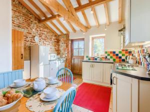 a kitchen with a table and chairs and a kitchen with a counter at 3 Bed in Norwich oc-owln8 in Corpusty