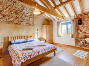 a bedroom with a bed and a brick wall at 3 Bed in Norwich oc-owln8 in Corpusty