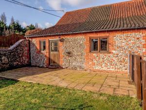 a brick house with a patio in front of it at 3 Bed in Norwich oc-owln8 in Corpusty