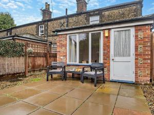 a patio with a table and two chairs in front of a building at 1 Bed in Wymondham oc-43278 in Wymondham