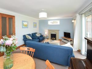 a living room with a blue couch and a table at 2 Bed in Dereham oc-57133 in Mattishall