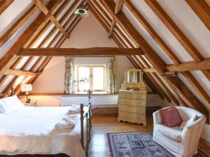 a bedroom with a bed and a chair in a attic at 3 Bed in Briston oc-kt187 in Briston