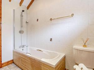 a bathroom with a bath tub and a toilet at 2 Bed in Dereham oc-57133 in Mattishall +12 photos
