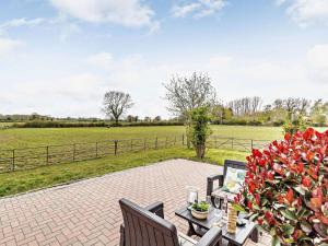 a patio with a table and chairs and a field at 2 Bed in Dereham oc-57133 in Mattishall