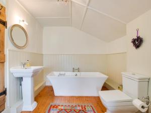 a bathroom with a tub and a sink and a toilet at 2 Bed in Syderstone oc-kt197 in Syderstone +17 photos