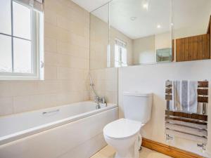 a bathroom with a toilet and a tub and a sink at 3 Bed in Kings Lynn oc-65596 in Heacham +13 photos
