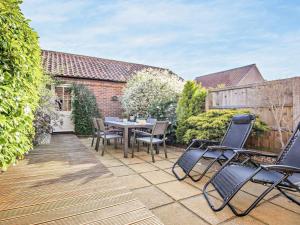 a patio with chairs and a table on a deck at 3 Bed in Kings Lynn oc-65596 in Heacham
