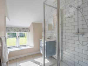 a bathroom with a shower and a tub and a window at 1 Bed in Bedford oc-79095 in Turvey