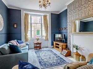a blue living room with a couch and a television at 3 Bed in Skegness oc-83461 in Wainfleet All Saints