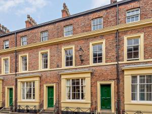 a large red brick building with green doors at 3 Bed in Skegness oc-83461 in Wainfleet All Saints