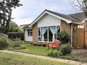 a house with a red chair in the yard at 3 Bed in Sheringham oc-86262 in Sheringham +11 photos