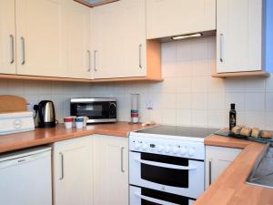 a kitchen with white cabinets and a stove top oven at 2 Bed in Norwich oc-75398 in Mundesley +4 photos