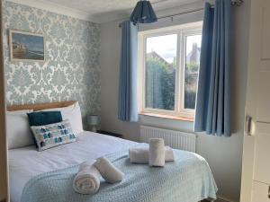 a bedroom with a bed with towels and a window at 2 Bed in Norwich oc-75398 in Mundesley