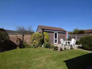 a yard with two chairs and a table and a house at 2 Bed in Norwich oc-75398 in Mundesley