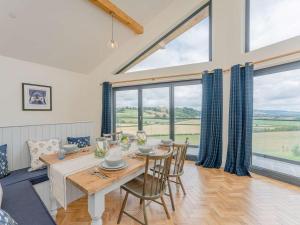 a dining room with a table and chairs and large windows at 3 Bed in Montgomery oc-88641 in Llandyssil