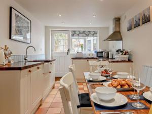 a kitchen with a table with plates of food on it at 3 Bed in Norwich oc-47835 in Haddiscoe