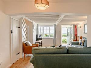 a living room with a green couch and a table at 3 Bed in Norwich oc-47835 in Haddiscoe
