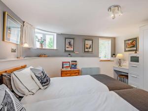 a bedroom with a large white bed and windows at 1 Bed in North Walsham oc-48723 in Bacton