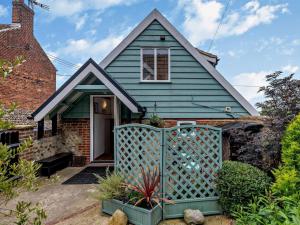 a green house with a gate in front of it at 1 Bed in North Walsham oc-48723 in Bacton