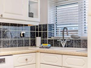 a kitchen with white cabinets and a sink at 2 Bed in Norwich oc-75392 in Bacton +14 photos