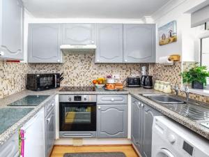 a kitchen with white cabinets and a sink at 2 Bed in Norwich oc-81322 in Walcott +11 photos
