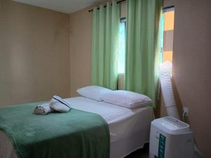 a bedroom with a bed and a window with green curtains at Apartmento em Carapibus in Conde +20 photos