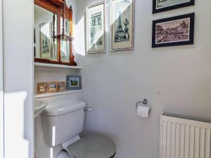 a bathroom with a toilet and some pictures on the wall at 2 Bed in Shereford oc-kt156 in Tatterford +17 photos