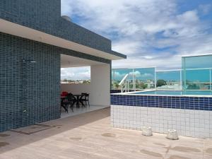a bathroom with blue tiles on the side of a house at Apartmento em Carapibus in Conde