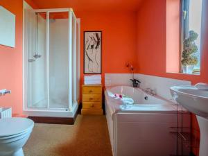 a bathroom with a tub and a toilet and a sink at 1 Bed in Bedford oc-78984 in Wyboston +7 photos
