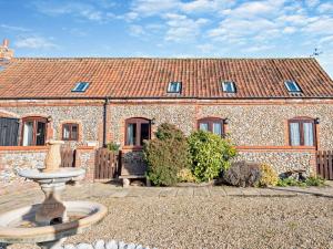 a stone house with a fountain in front of it at 3 Bed in Kings Lynn oc-75673 in Tattersett
