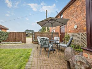 a patio with a table and chairs and an umbrella at 2 Bed in Louth oc-74152 in North Somercotes