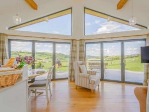a living room with large windows and a table and chairs at 2 Bed in Montgomery oc-83244 in Llandyssil
