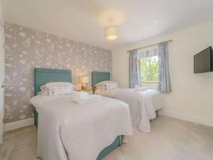 a room with three beds with white sheets and a window at 2 Bed in Montgomery oc-83244 in Llandyssil