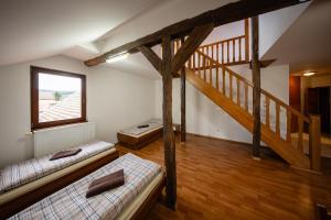a attic room with two beds and a staircase at Penzion U Holuba in Hradčovice