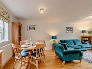 a living room with a table and a blue couch at 2 Bed in Holt oc-72898 in Holt
