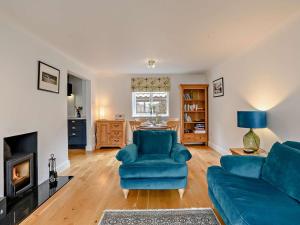 a living room with a blue couch and a fireplace at 2 Bed in Holt oc-72898 in Holt