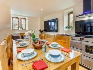 a kitchen with a wooden table with dishes on it at 4 Bed in Ashford oc-86647 in Ashford