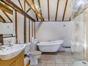 a bathroom with a tub and a toilet and a sink at 1 Bed in Dunmow oc-51222 in Thaxted