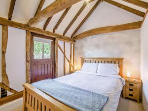 a bedroom with a bed with a wooden frame and a window at 1 Bed in Dunmow oc-51222 in Thaxted