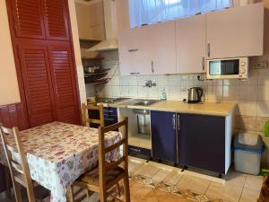 a small kitchen with a table and a microwave at Karikás Apartman in Hajdúszoboszló