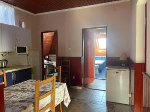a kitchen and dining room with a table and a table and a room at Karikás Apartman in Hajdúszoboszló