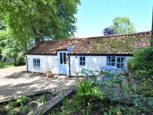 a small white cottage with a garden in front of it at 1 Bed in Holt oc-ncc04 in Cley next the Sea