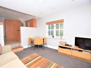 a living room with a table and a television at 1 Bed in Holt oc-ncc04 in Cley next the Sea