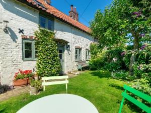 a white house with a bench in the yard at 2 Bed in Syderstone oc-kt146 in Syderstone