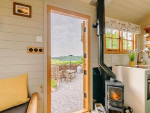 an open door to a tiny house with a wood stove at 1 Bed in Canterbury oc-88795 in Chillenden